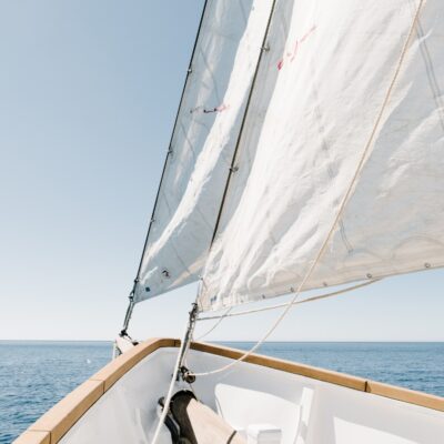 Jacht z żaglem na tle morza i nieba